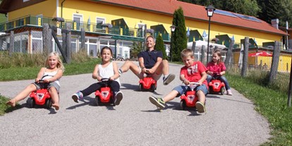 Naturhotel - Kinderbetreuung - Kärnten - Bobbycar fahren im Spätsommer - Bio-Bauernhof Petschnighof