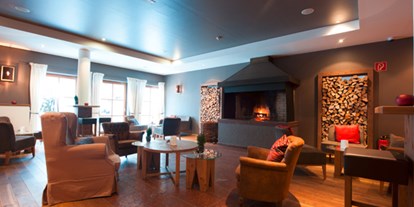 Naturhotel - Allergiker-Zimmer - Tirol - Ausspannen am offenen Kamin im Bereich der Bar - Q! Resort Health & Spa Kitzbühel