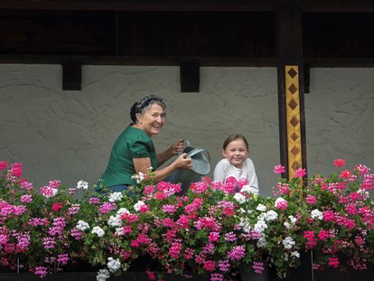 Naturhotel - Umgebungsschwerpunkt: Berg - Zöblen - Seniorchefin Ulrike bei der Pflege der Blumenpracht. - Biohotel Walserstuba