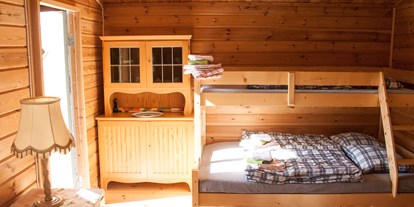 Naturhotel - Hunde erlaubt - Schweden - Ferienhütte von innen mit viel Holz. - Lilla Sverigebyn