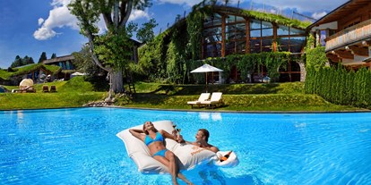 Naturhotel - Sonnenterrasse - Leogang - Familien-Sport-Pool mit begrünter Tennishalle im Hintergrund - Biohotel Stanglwirt