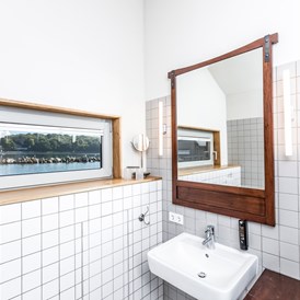 Biohotel: Pfahlhaussuiten
Badezimmer mit Dusche. - im-jaich Wasserferienwelt